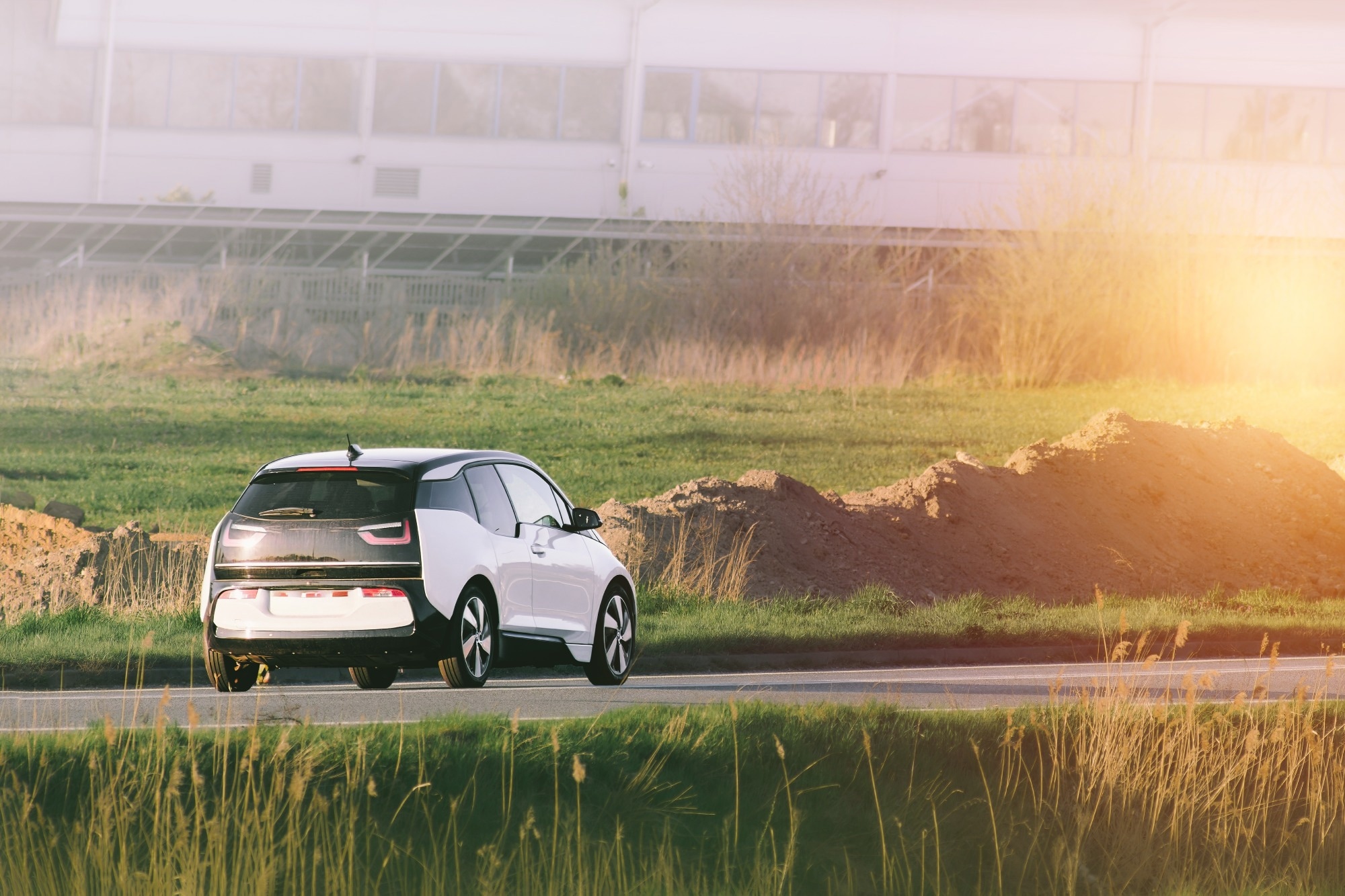 electric SUV next to green field