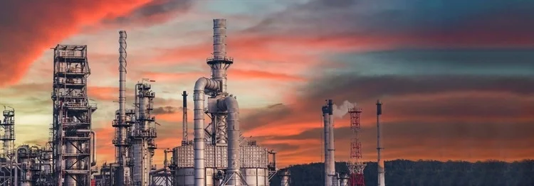 Large factory against a sunset.