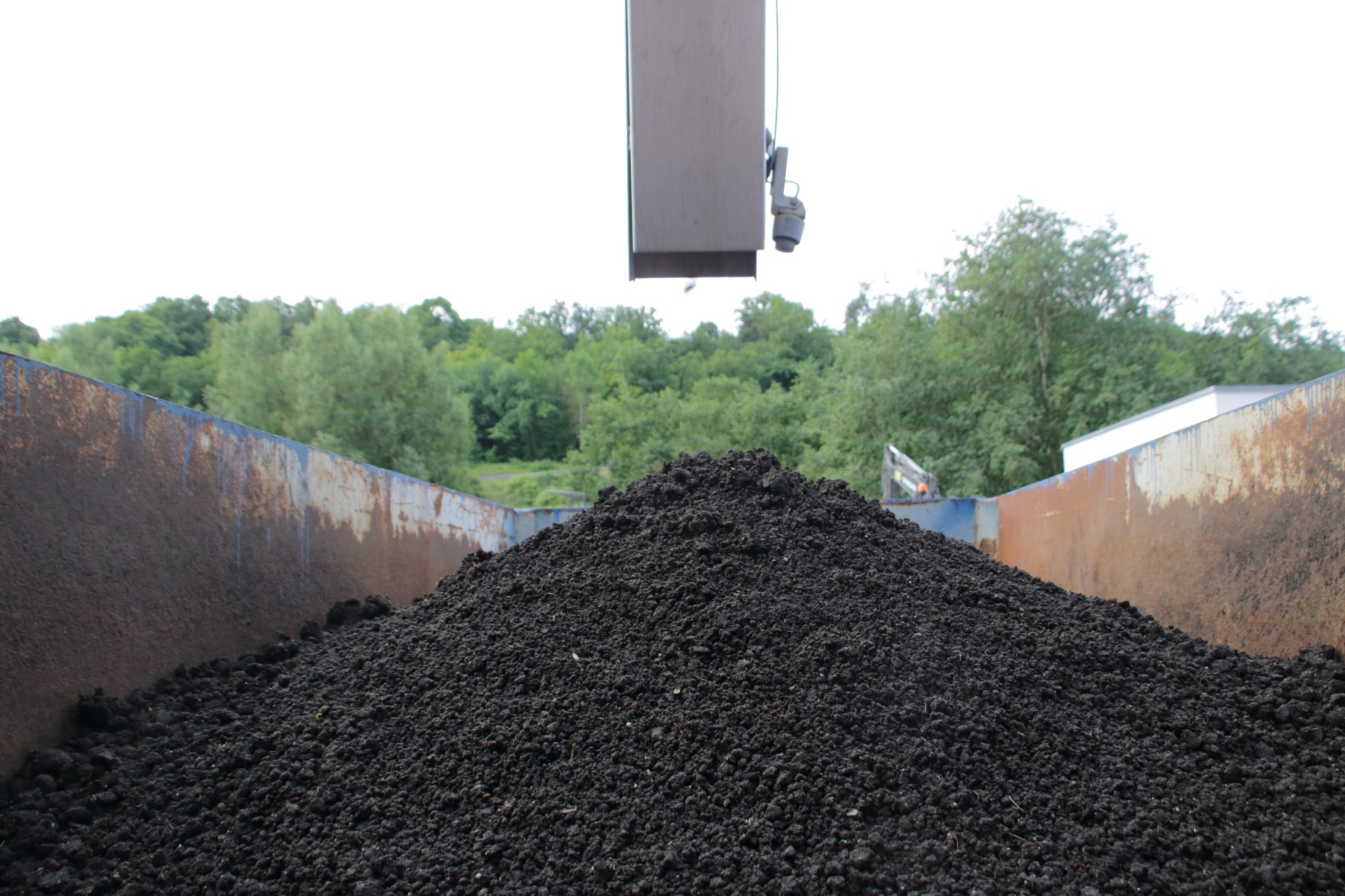 sewage sludge being poured into container
