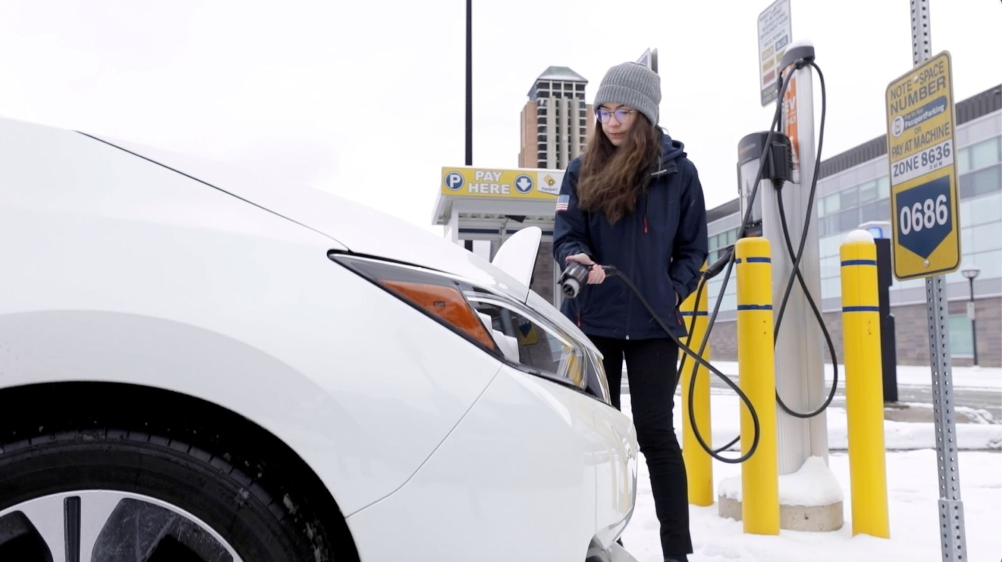 Engineering student Chloe Acosta plugs in an EV for charging in snowy weather on the University of Michigan’s North Campus. EV charging becomes less efficient in colder weather, but a new strategy for manufacturing battery electrodes could enable charging in 10 minutes in temperatures as cold as -10 ºC
