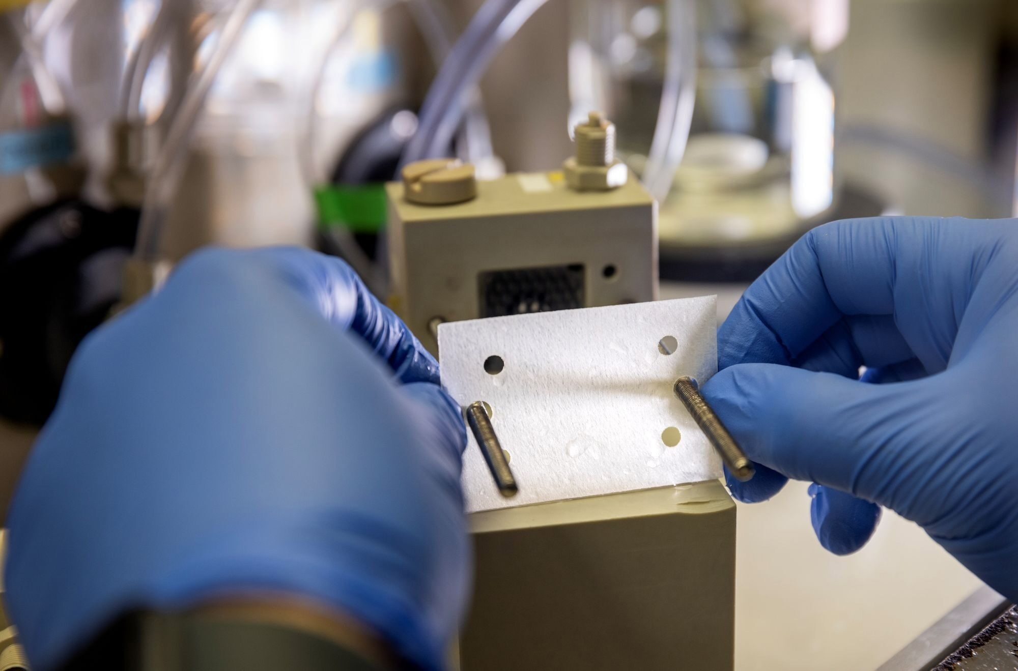Jovan Kamcev, assistant professor of chemical engineering, places a membrane into an electrodialysis device.