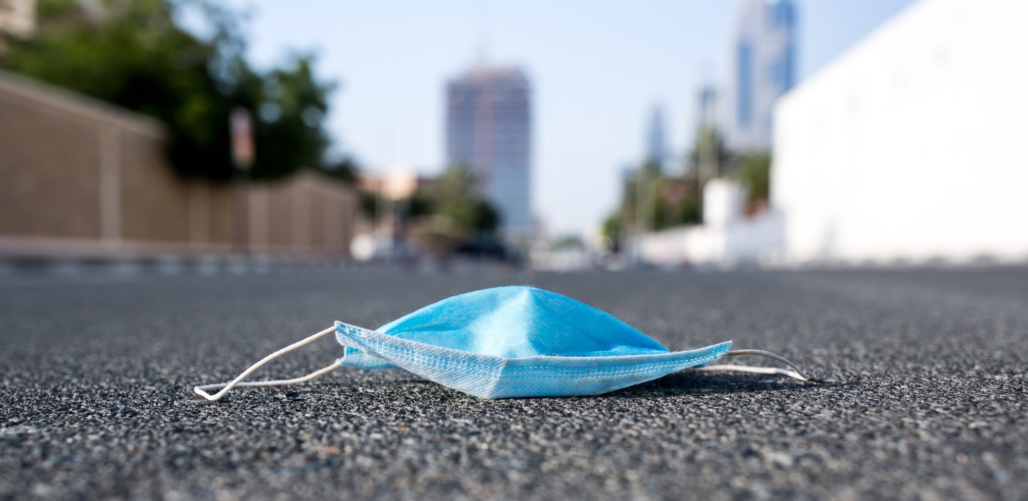 Disposable face mask lying on concrete floor.
