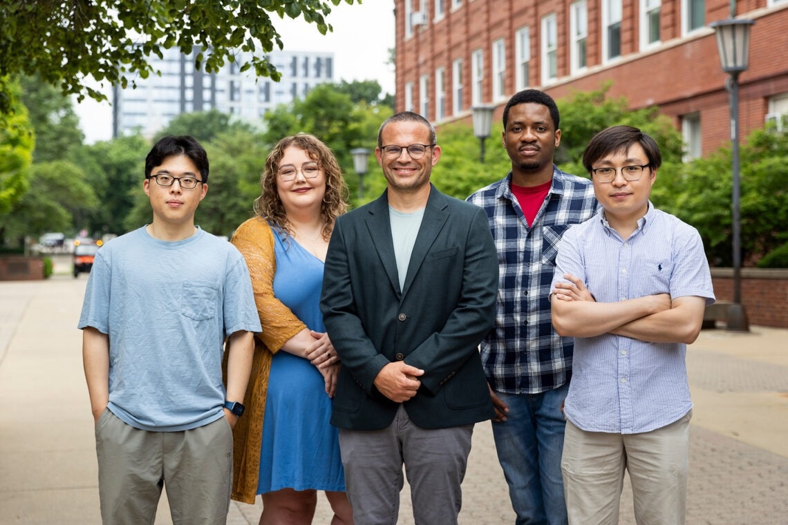 The research group standing together in front of their laboratory building.
