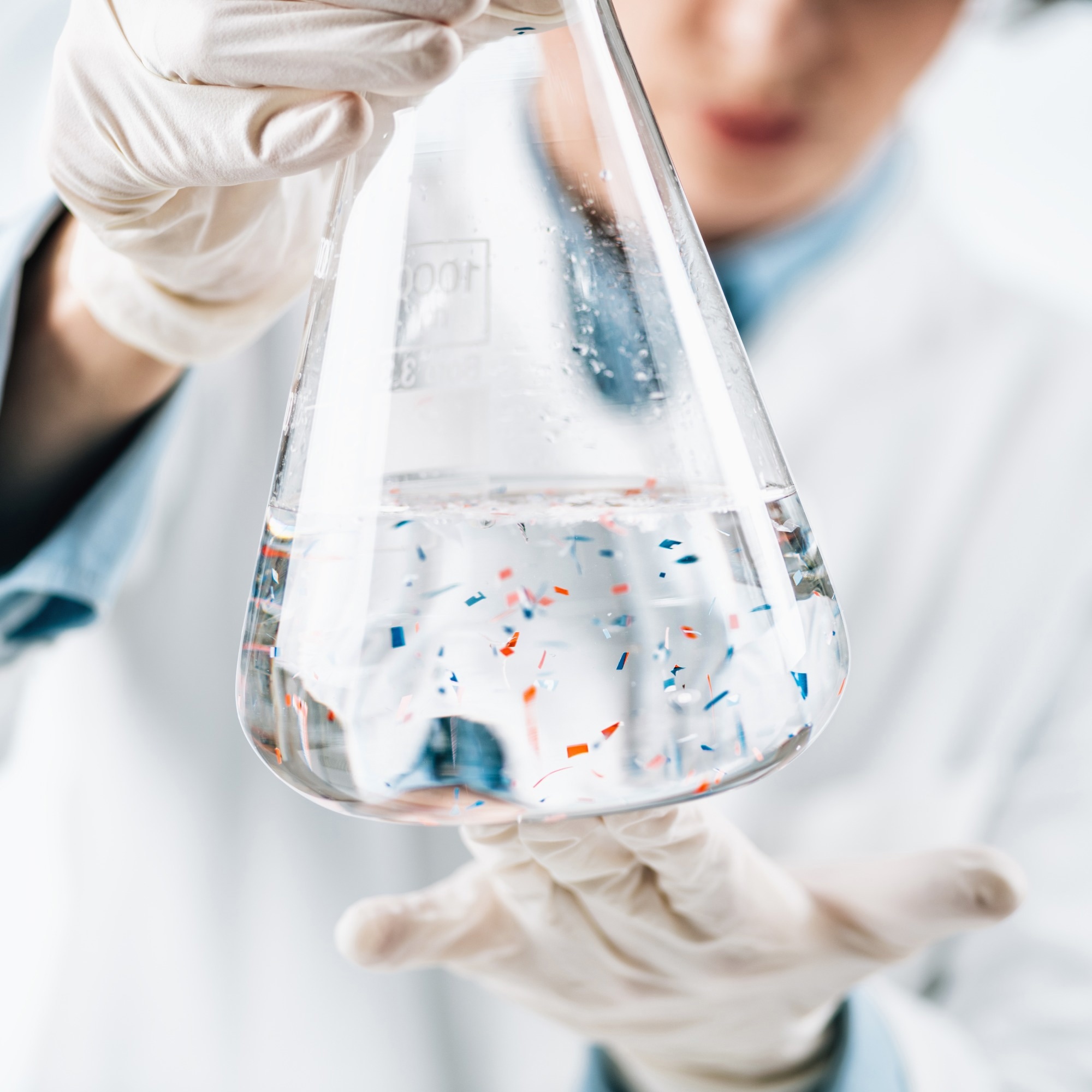 scientist holding water with microplastics inside